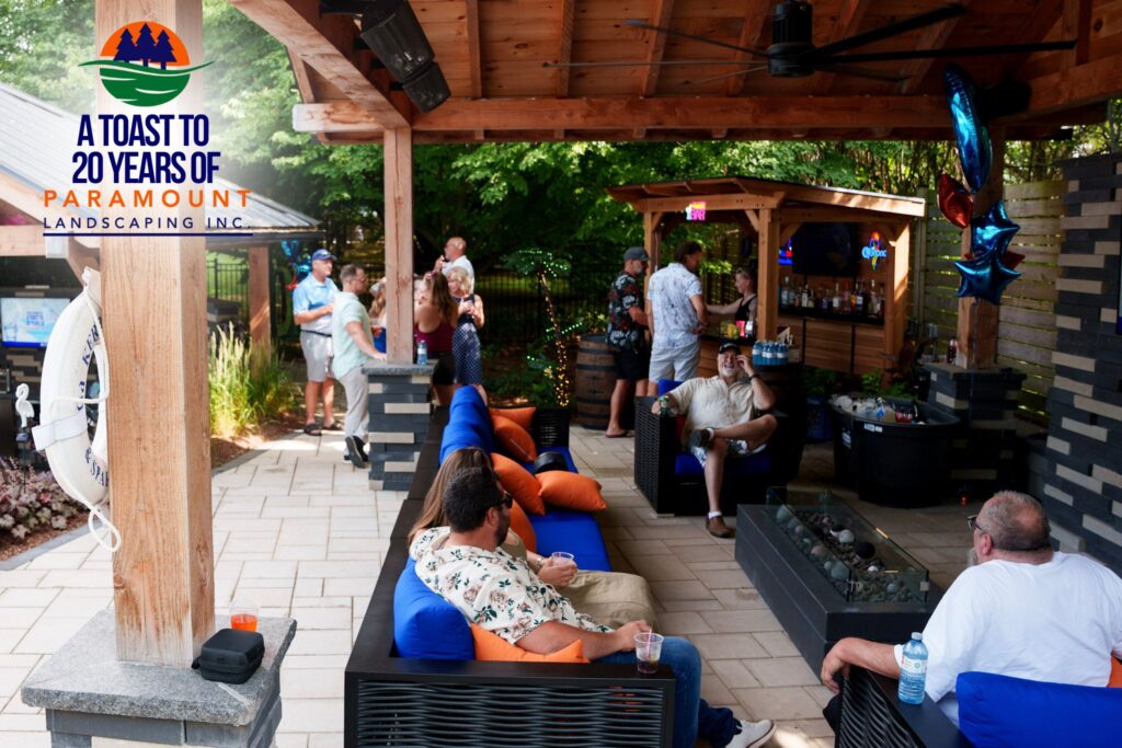 Guests enjoying drinks and conversation under the wood pergola next to the firepit and Discovery Lounge.