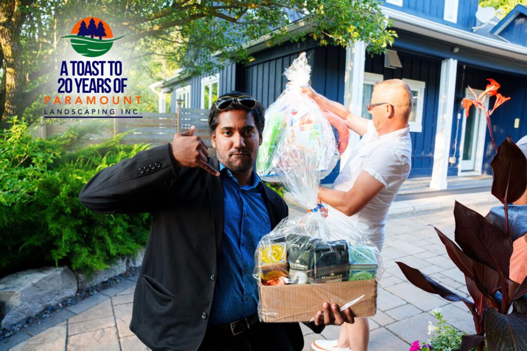 Prize winners Arshaad Mustafa and Lou Burmazovic holding their giveaway packs—Rise & Shine Kit and Pool Party Pack—at Paramount Landscaping’s 20th Anniversary event.