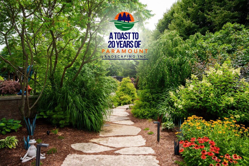Flagstone path surrounded by lush landscaping leading from the pool area to the pond and waterfall at Paramount Landscaping’s 20th Anniversary celebration.
