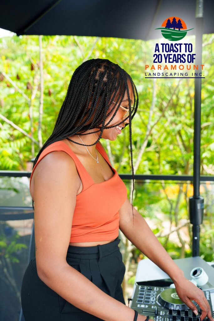 DJ Special Kay performing live at Paramount Landscaping’s 20th Anniversary celebration, set against a lush outdoor backdrop.