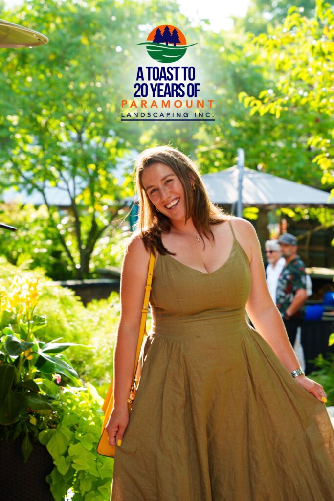 Sarah, wife of Vito from Halton Pool Guys, smiling at Paramount Landscaping’s 20th Anniversary celebration in the garden area.
