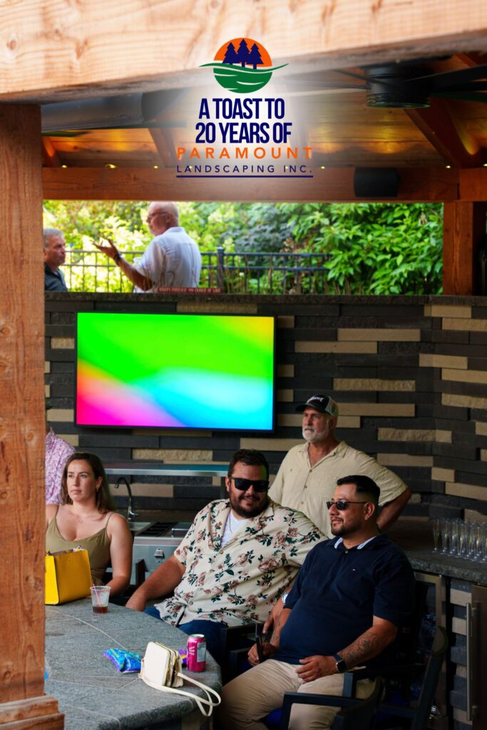 Guests seated and enjoying drinks in the sunken bar area at Paramount Landscaping’s 20th Anniversary celebration, surrounded by lush greenery and vibrant décor.